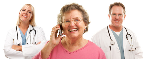 Image showing Happy Senior Woman Using Cell Phone and Doctors Behind