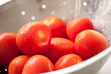 Image showing Fresh, Vibrant Roma Tomatoes in Colander with Water Drops