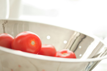 Image showing Fresh, Vibrant Roma Tomatoes in Colander with Water Drops