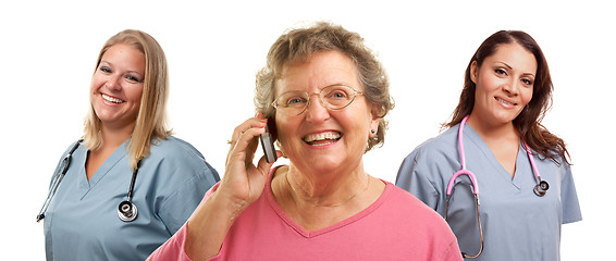 Image showing Senior Woman Using Cell Phone and Female Doctors Behind