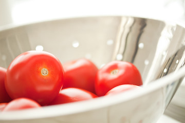 Image showing Fresh, Vibrant Roma Tomatoes in Colander with Water Drops