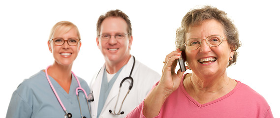 Image showing Happy Senior Woman Using Cell Phone and Doctors Behind