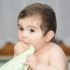 Image showing Baby biting green towel