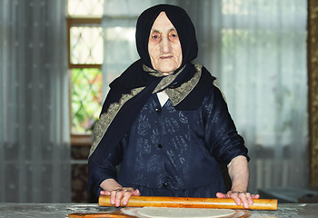 Image showing Elderly woman rolling out dough