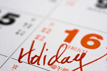 Image showing Hand writing holiday on calendar