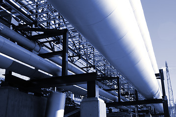 Image showing industrial pipelines on pipe-bridge against blue sky 