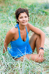 Image showing brunet woman sitting in a grass