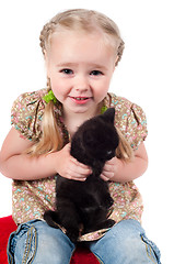 Image showing Little girl playing with kitten