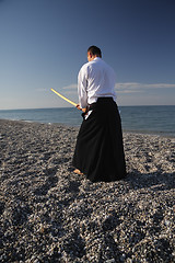 Image showing Man exercising with sword rear view