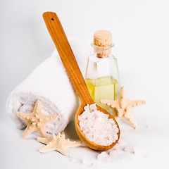 Image showing sea salt on wooden spoon, towel, oil and stars