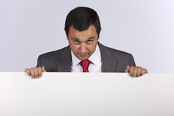 Image showing Businessman holding a blank billboard