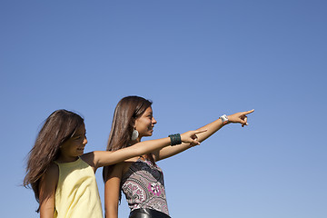 Image showing Happy sisters pointing away