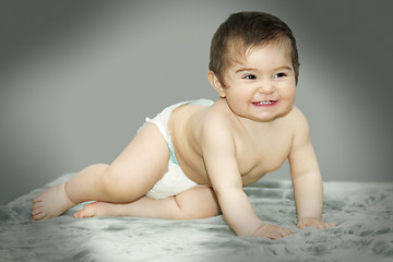 Image showing Baby sitting on gray carpet