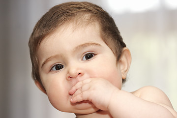 Image showing Cute baby with hand at mouth
