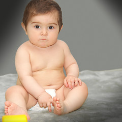 Image showing Serene baby sitting on gray carpet