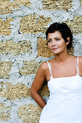 Image showing woman in white dress near a brick wall