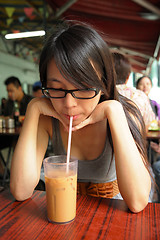 Image showing girl drinking a Hong Kong-style milk tea in Dai pai dong