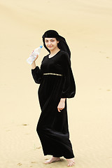 Image showing Smiling barefoot woman with water bottle