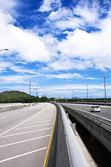 Image showing road through the bridge with blue sky background of a city. 