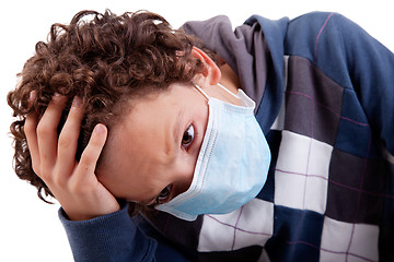 Image showing young boy with a medical mask, and the hand on head