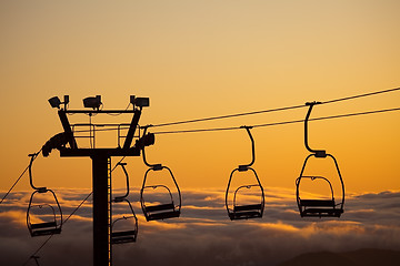 Image showing ski lift over clouds in sunset