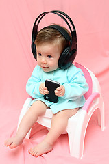 Image showing baby in headphones on chamber-pot