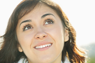 Image showing Young brunette in sunlight looking up