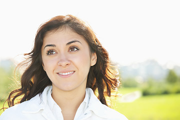 Image showing Young smiling brunette looking up