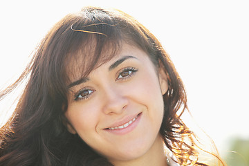 Image showing Young smiling brunette in sunlight