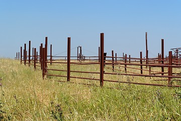 Image showing Rusty fence of the empty cattle-pen in bright summer day