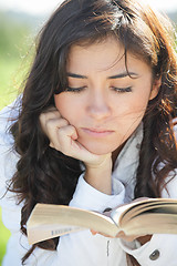 Image showing Young brunette reading book