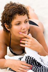 Image showing brunet woman lying on a sand