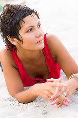 Image showing woman in red lying on a sand