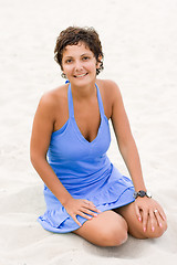 Image showing woman in blue sitting in a sand