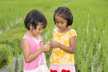 Image showing asian girls with grasshopper