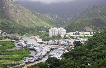 Image showing Small fishing village at a base of a high mountain