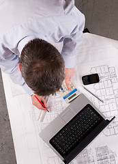 Image showing Architect examines plans