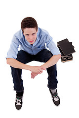 Image showing young and beautiful boy  seated on floor, with some books