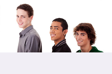 Image showing three young, of different colors man holding a white board