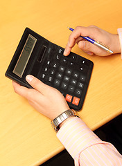 Image showing businessman counts money on calculator