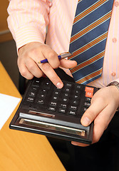 Image showing businessman counts money on calculator