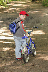 Image showing Boy with bicycle glancing back