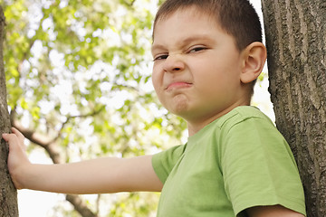 Image showing Grimacing boy between trees