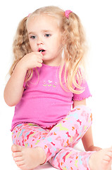 Image showing Little cute girl in studio eating candy