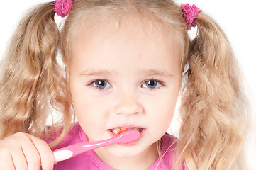 Image showing Little cute girl in studio brushing teeth