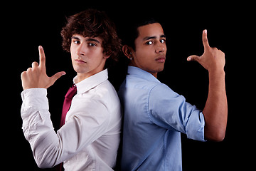 Image showing two young man of different colors, back to back, with hand as an police officer with weapon raised