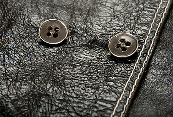 Image showing Metal buttons on black leather clothing