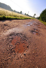 Image showing Red clay road with holes