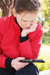 Image showing Woman in red reading electronic book