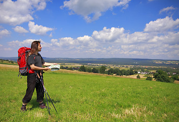 Image showing Tourist with backpack, map and trekking sticks